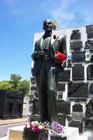 Carlos Gardel's statue with fresh flowers and cigar.